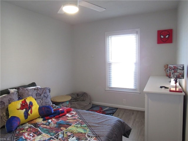 bedroom with light wood-style floors, baseboards, and a ceiling fan