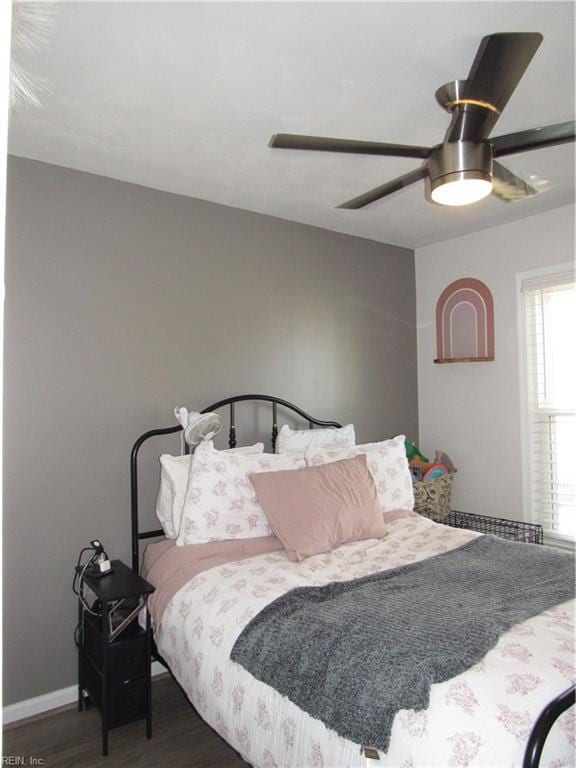 bedroom featuring ceiling fan, baseboards, and dark wood finished floors