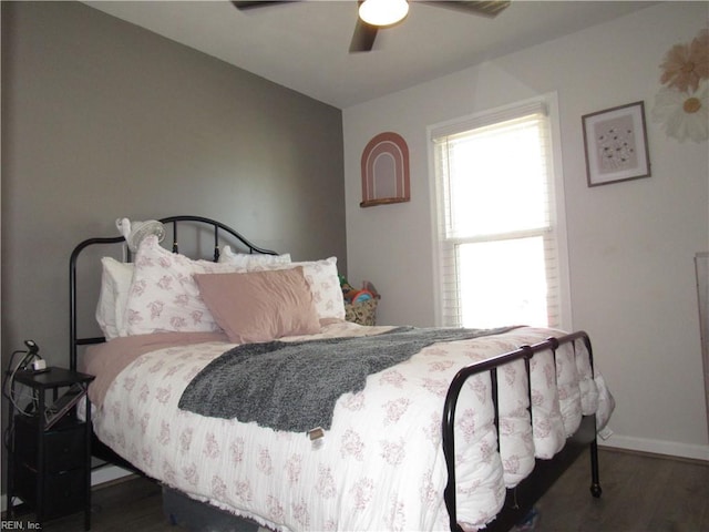 bedroom with ceiling fan, dark wood-type flooring, and baseboards