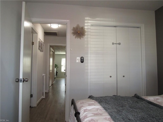 bedroom with a closet, visible vents, and wood finished floors