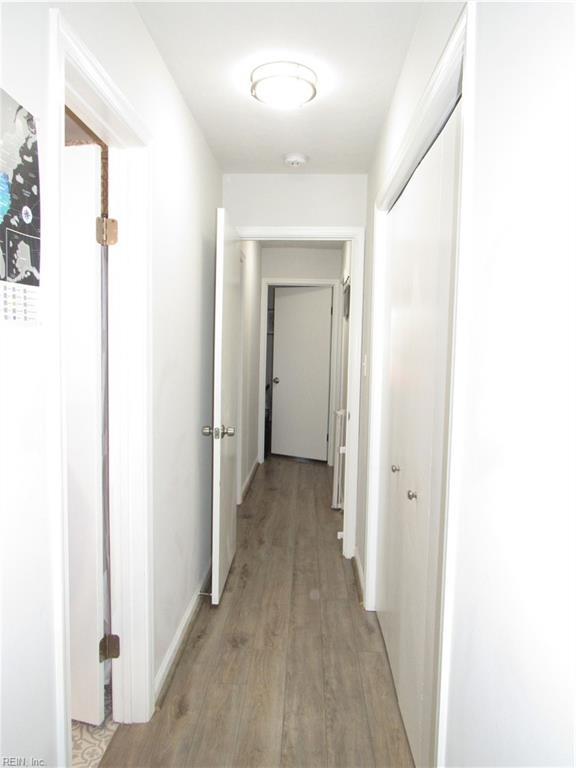 hall featuring light wood finished floors and baseboards