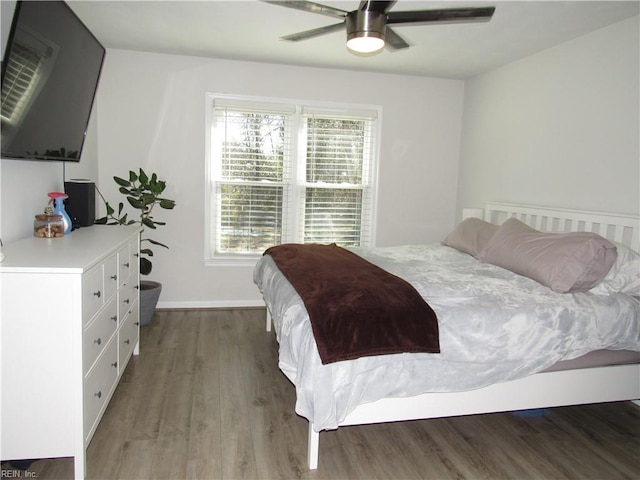 bedroom featuring ceiling fan, baseboards, and wood finished floors