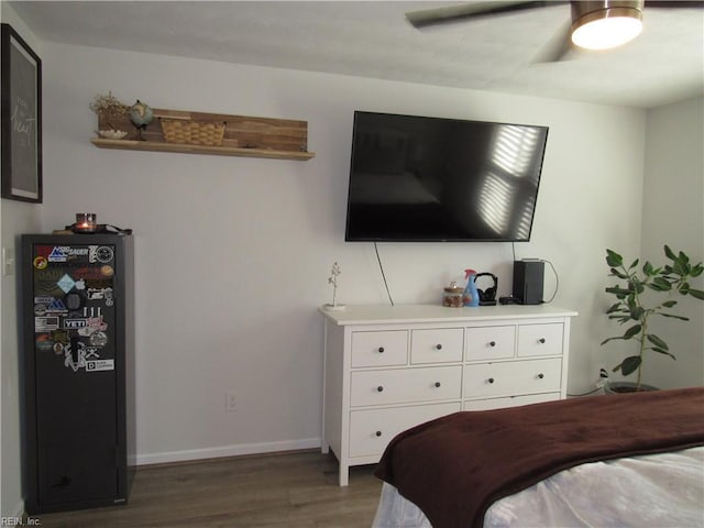 bedroom with a ceiling fan, baseboards, and dark wood-style flooring