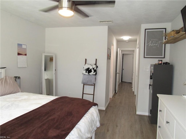 bedroom featuring light wood-style flooring, visible vents, and baseboards