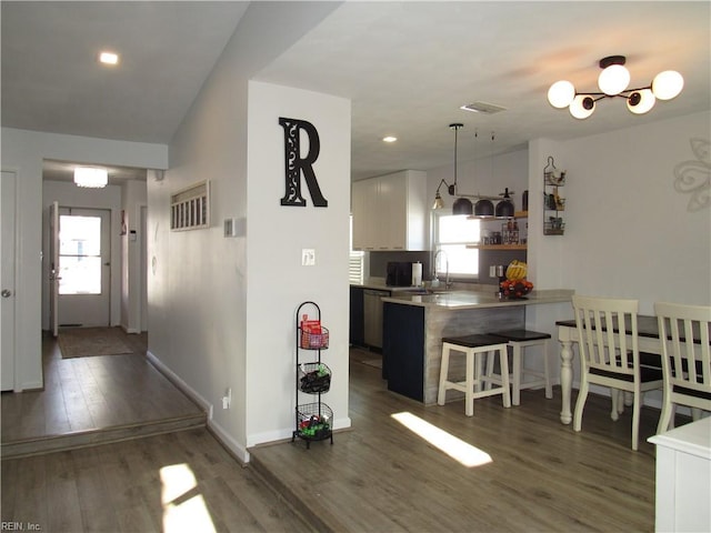 kitchen featuring a peninsula, a breakfast bar, plenty of natural light, and open shelves