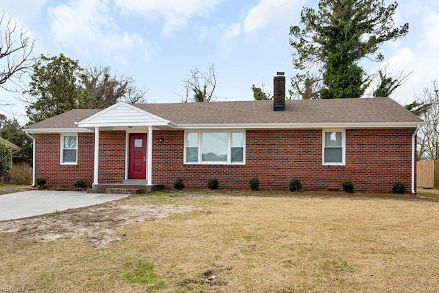 single story home with a shingled roof, a chimney, a front lawn, and brick siding