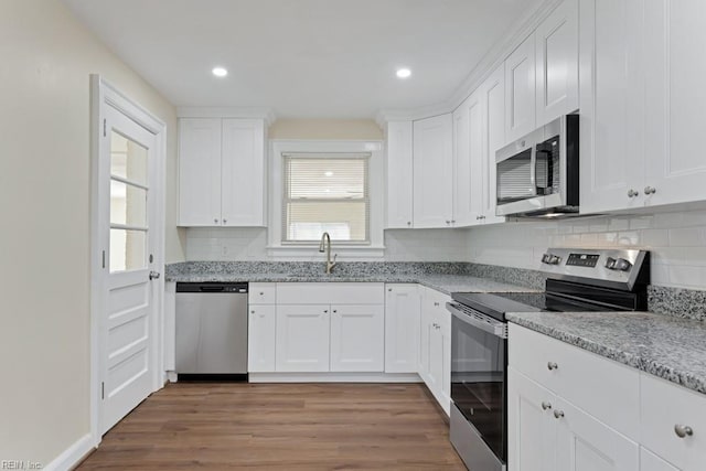 kitchen featuring appliances with stainless steel finishes, white cabinetry, and a sink