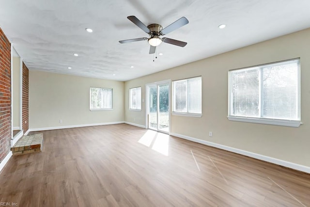 unfurnished room with recessed lighting, brick wall, a ceiling fan, light wood-style floors, and baseboards