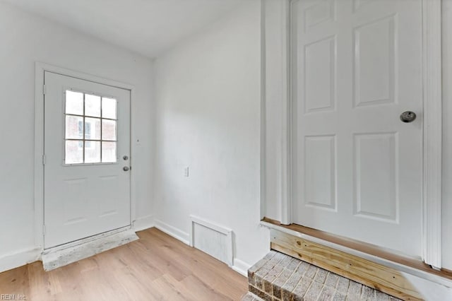 doorway to outside featuring light wood finished floors and baseboards