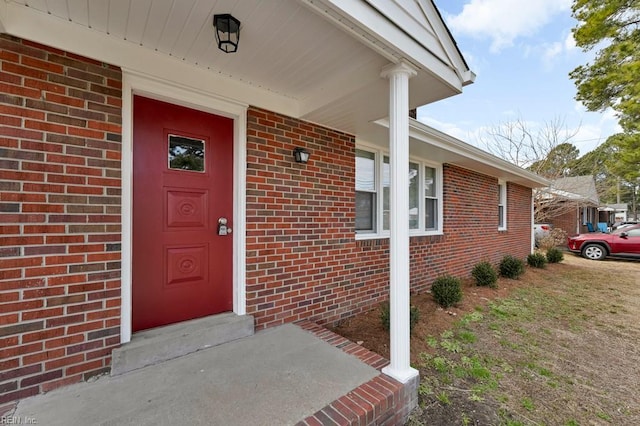 entrance to property featuring brick siding