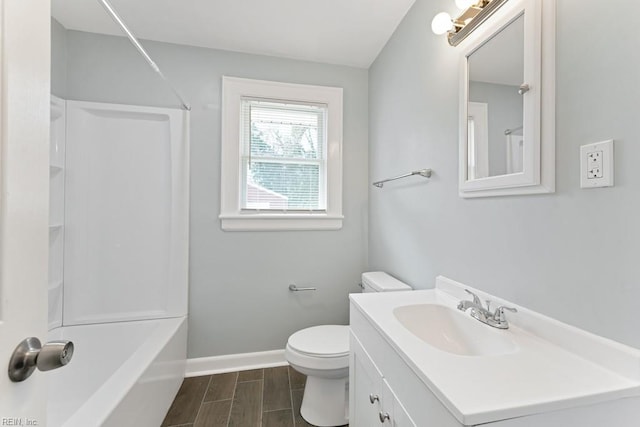 full bath with bathtub / shower combination, toilet, wood finish floors, vanity, and baseboards