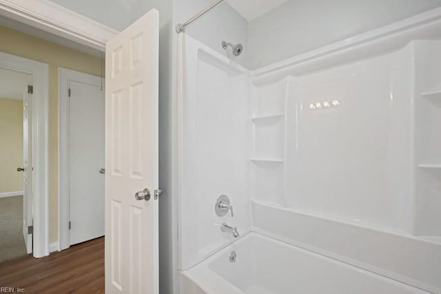 full bathroom with shower / washtub combination and wood finished floors