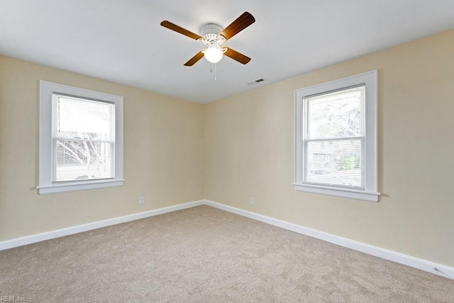 spare room featuring light carpet, baseboards, and visible vents