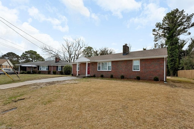 ranch-style home featuring a front yard, brick siding, and a chimney