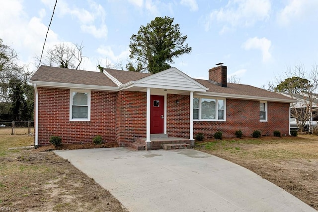 single story home with a front yard, a chimney, and brick siding