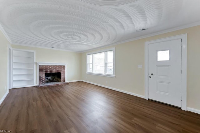 unfurnished living room with dark wood-style floors, built in shelves, baseboards, and crown molding