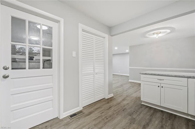 interior space featuring wood finished floors, visible vents, and baseboards