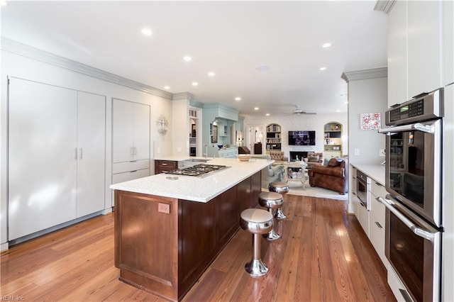 kitchen featuring a center island, stainless steel appliances, open floor plan, white cabinetry, and modern cabinets