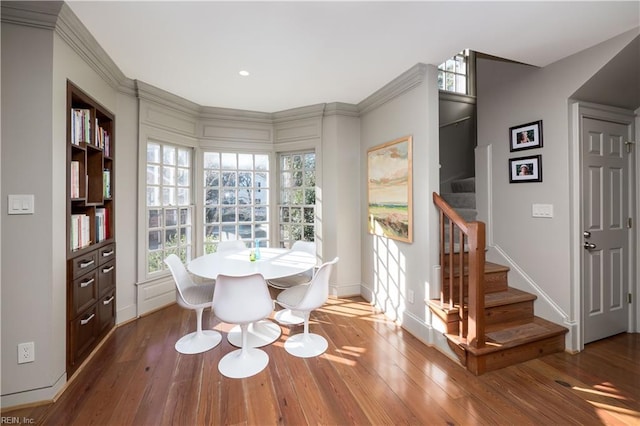 dining space with baseboards, stairway, and wood finished floors