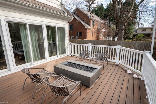 wooden terrace featuring an outdoor fire pit and fence