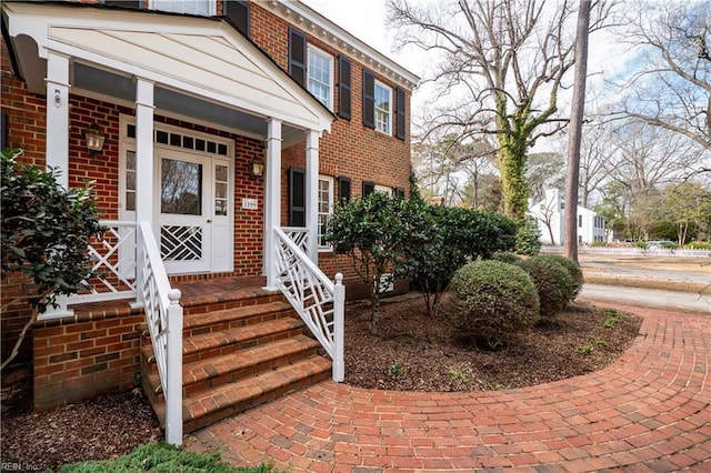 view of exterior entry featuring brick siding