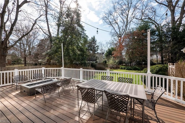 wooden deck with fence, a fire pit, and outdoor dining area