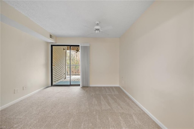 empty room featuring light carpet, a textured ceiling, and baseboards