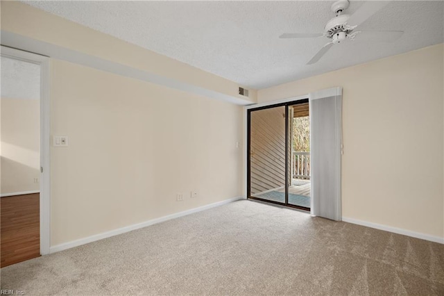 empty room featuring carpet floors, visible vents, baseboards, and a textured ceiling