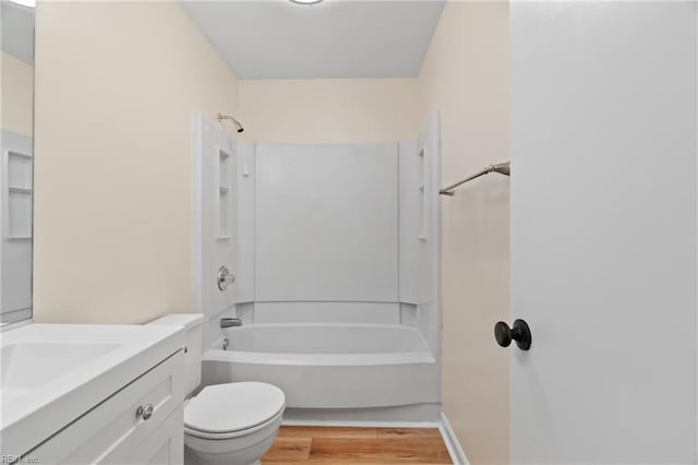 bathroom with toilet, shower / bathing tub combination, wood finished floors, and vanity