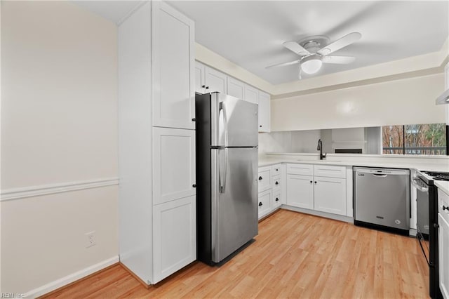 kitchen featuring a sink, stainless steel appliances, light countertops, and white cabinetry