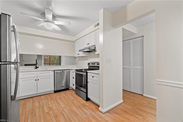 kitchen with white cabinetry, appliances with stainless steel finishes, light countertops, and a sink