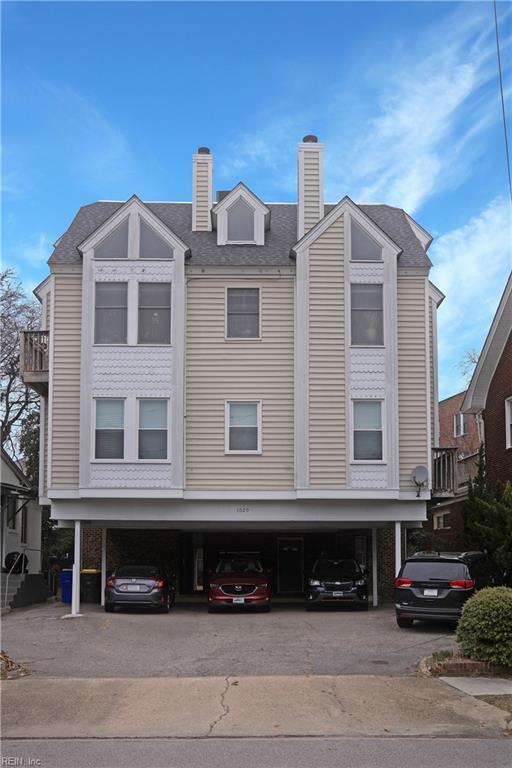 exterior space with a shingled roof and a chimney