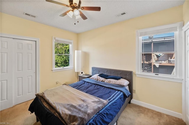 bedroom featuring baseboards, visible vents, and light colored carpet