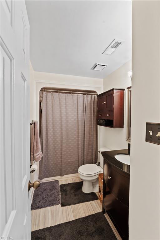 bathroom with visible vents, toilet, vanity, and a shower with shower curtain