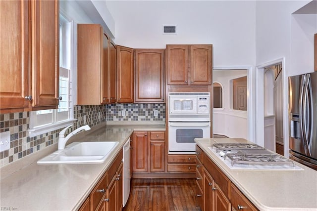 kitchen featuring stainless steel appliances, light countertops, a sink, and visible vents