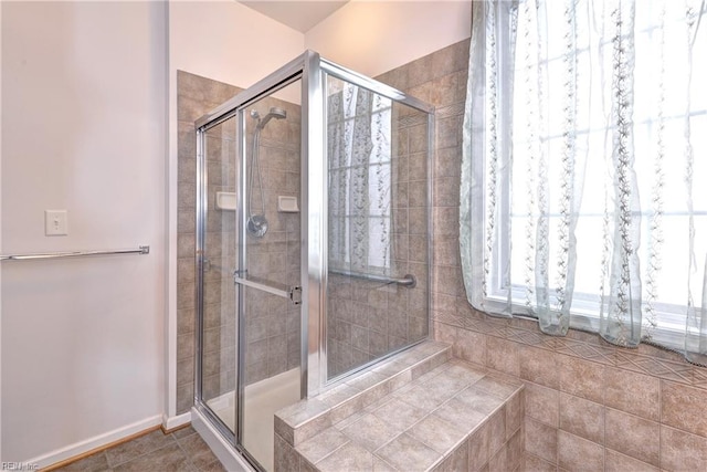 full bathroom featuring baseboards, a stall shower, and tile patterned floors