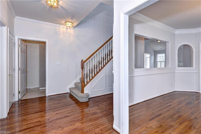 entryway with ornamental molding, dark wood-type flooring, stairs, and baseboards