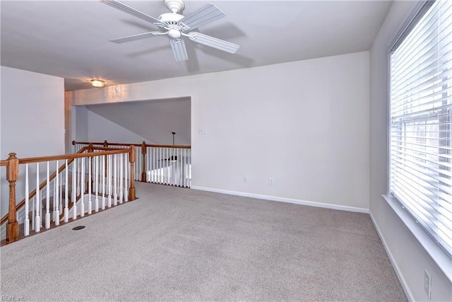 empty room featuring a ceiling fan, carpet flooring, and baseboards