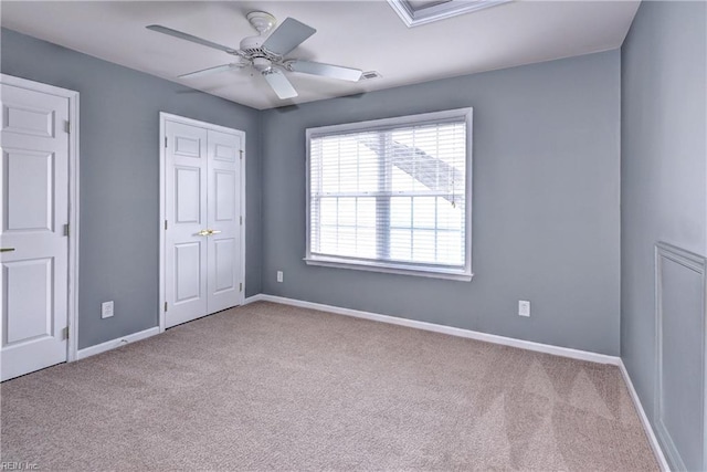 unfurnished bedroom with light carpet, ceiling fan, a closet, and baseboards