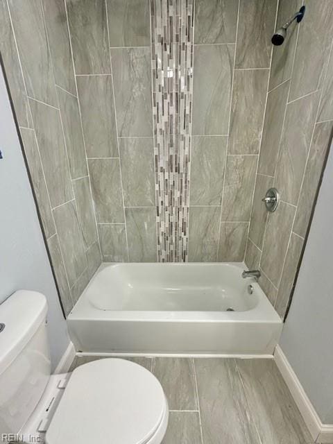 full bathroom featuring toilet, baseboards, and bathing tub / shower combination