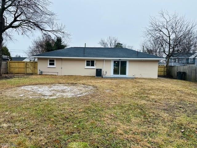 back of house with a fenced backyard, central AC unit, a lawn, and stucco siding