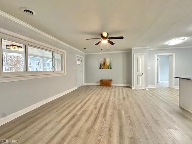 empty room featuring crown molding, visible vents, light wood-style floors, ceiling fan, and baseboards