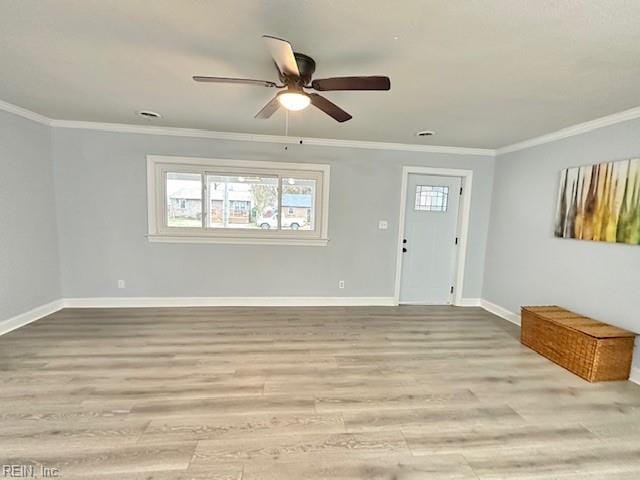 interior space featuring a ceiling fan, crown molding, baseboards, and wood finished floors