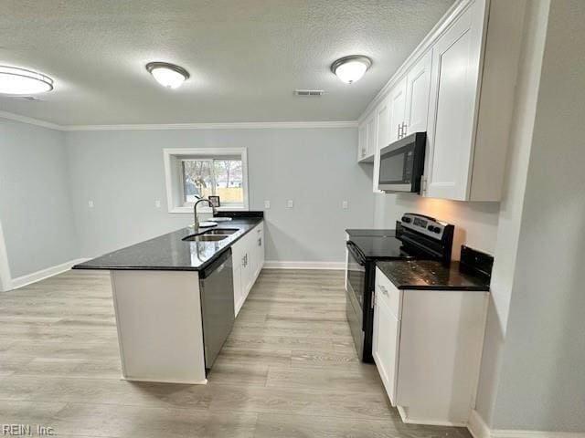 kitchen with dark countertops, electric range, stainless steel dishwasher, a sink, and a peninsula