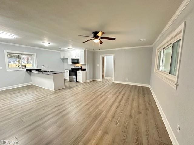 kitchen with white cabinetry, ornamental molding, stainless steel appliances, and open floor plan