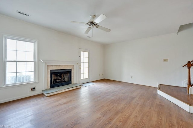 unfurnished living room featuring a fireplace, visible vents, baseboards, a ceiling fan, and light wood-style floors