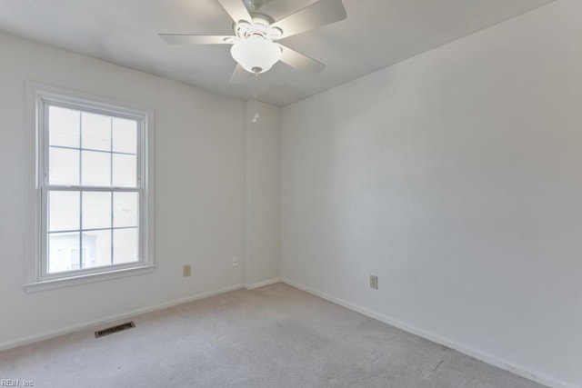 unfurnished room featuring baseboards, visible vents, ceiling fan, and light colored carpet