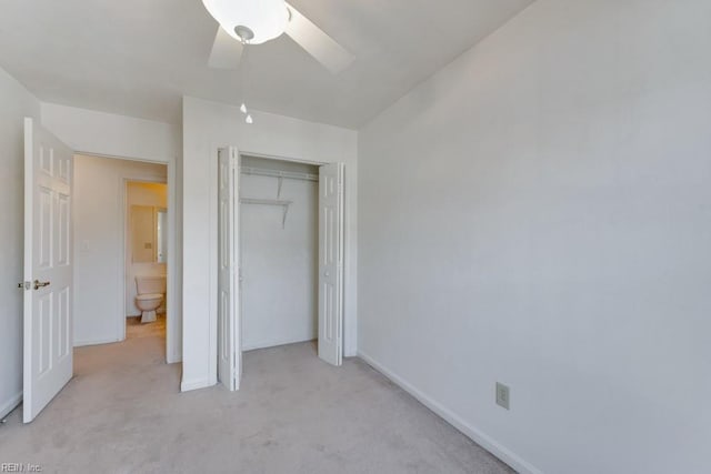 unfurnished bedroom featuring a closet, light carpet, ceiling fan, and baseboards