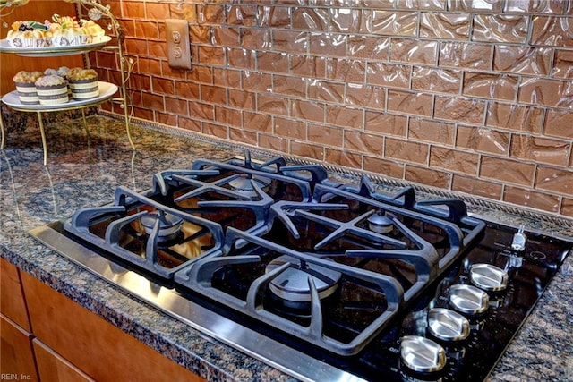 details with dark stone counters and stainless steel gas cooktop