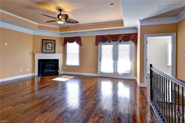 unfurnished living room with dark wood-style floors, a fireplace with flush hearth, visible vents, and a raised ceiling